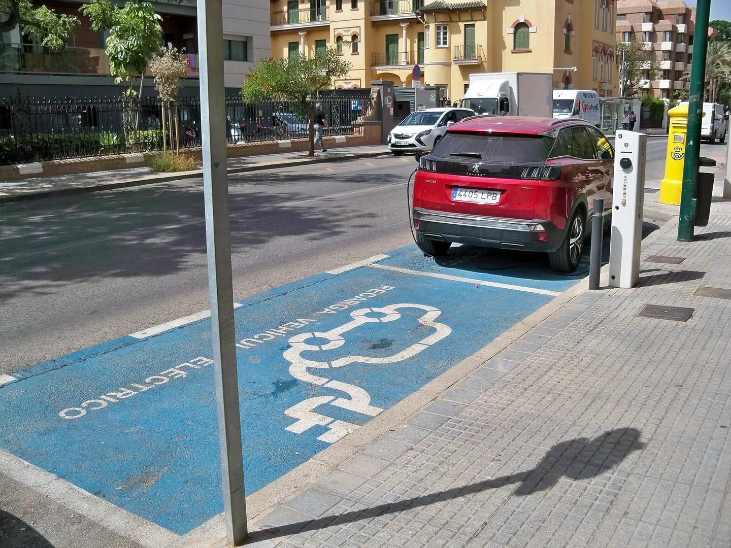 Coche eléctrico cargando en una plaza reservada de una calle de Málaga